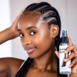Person with cornrow braids holding a braid spray bottle.